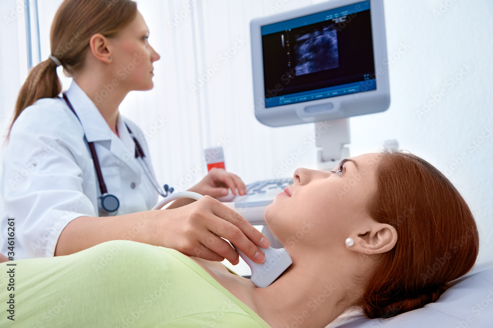 woman getting ultrasound of a thyroid from doctor - obrazy, fototapety, plakaty 