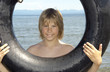Boy holding a tube at the beach