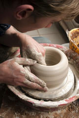 hands of a potter, creating an earthen jar on the circle