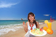 コマカ島の浜辺でランチを食べる女性