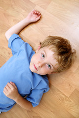 Serious boy lying on the floor