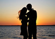 Silhouettes of amorous couple on a background of a sunset