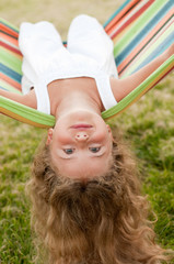 Happy little girl playing in colorful hammock