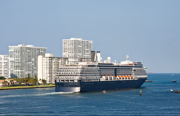 Blue and White Cruise Ship Sailing out of Channel