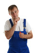Handwerker mit blauer Latzhose hält einen Schraubenzieher