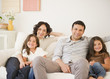 © JGI/Jamie Grill/Blend Images - Happy family sitting on sofa together