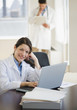 © JGI/Jamie Grill/Blend Images - Mixed race doctor working on laptop