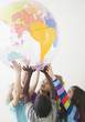 © JGI/Jamie Grill/Blend Images - Children lifting up plastic globe