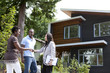 © Noel Hendrickson/Blend Images - Real estate agent greeting couple at house