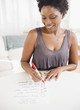 © JGI/Jamie Grill/Blend Images - Black woman checking off to do list