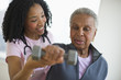 © JGI/Tom Grill/Blend Images - Nurse helping woman exercise with dumbbell