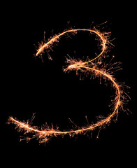 Digit 3 made of sparklers isolated on black