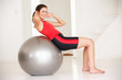 © Monkey Business - Woman with gym ball in home gym