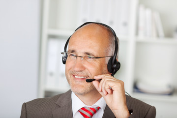 Poster - lächelnder geschäftsmann mit headset