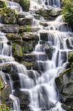 Beautiful waterfall cascades over rocks in lush forest landscape