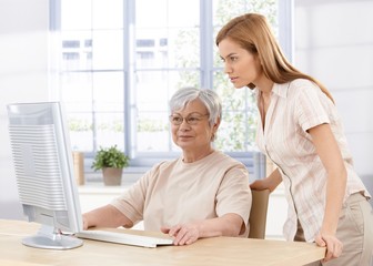 senior mother and daughter using computer