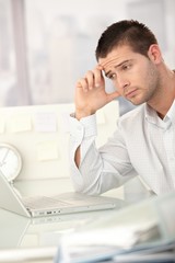 Canvas Print - Tired businessman working on laptop