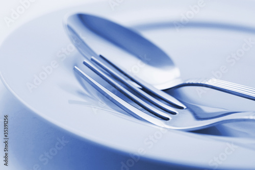 Board z aluminiowym obramowaniem Widelec i łyżka na talerzu.