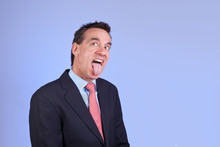 Attractive Business Man In Suit Sticking Out Tongue
