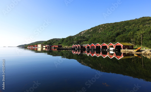 Obraz na płótnie canvas trzyczęściowy "tryptyk" Rząd czerwonych kolorowych boathouses w fiordu w Skandynawii