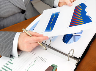 Fototapete - Businesswoman analyzing investment charts at his workplace