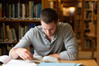 © WavebreakmediaMicro - Male student researching with a book