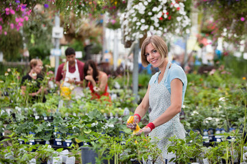 Wall Mural - Beautiful woman spraying water on plants