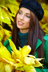 Wall Mural - Beautiful elegant woman standing in a park in autumn