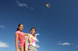 © micromonkey - Teenage girls flying a kite