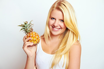 young blond woman with a fresh pineapple