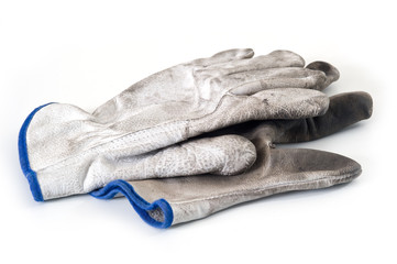 Old dirty leather work gloves isolated.