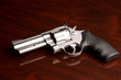 Clean .357 revolver laying on reflective wooden table