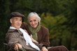 © auremar - Elegant elderly couple sitting on a park bench