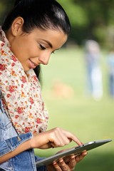 Poster - Pretty girl using tablet outdoors smiling