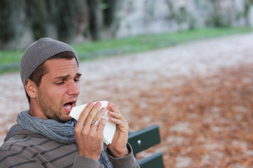 Man sneezing into tissue