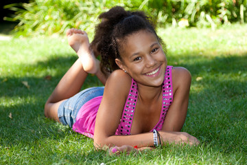 Young black teenage girl  lying on the grass