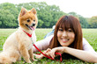 © taka - attractive asian woman with dog in the park