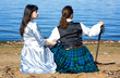 © darkbird - Woman and man in scottish costume sitting near the sea