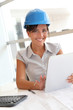 © goodluz - Smiling woman architect in office working with electronic tablet