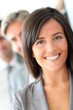 © goodluz - Beautiful saleswoman standing with group of business people