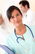 © goodluz - Beautiful nurse standing with medical people
