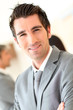 © goodluz - Portrait of smiling businessman standing in hall