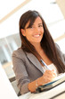 © goodluz - Portrait of beautiful businesswoman writing notes on agenda