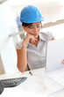© goodluz - Smiling woman architect in office working with electronic tablet