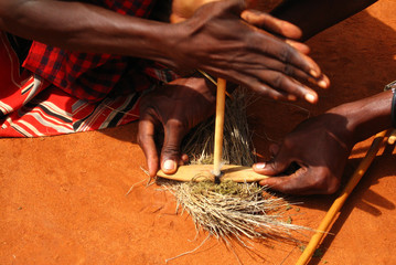 Two Masai light fire in traditional way