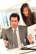© goodluz - Business team using electronic tablet at work