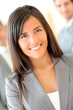 © goodluz - Portrait of beautiful businesswoman standing in front of group