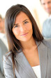© goodluz - Portrait of beautiful businesswoman standing in front of group