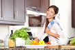 Woman in kitchen making food happy