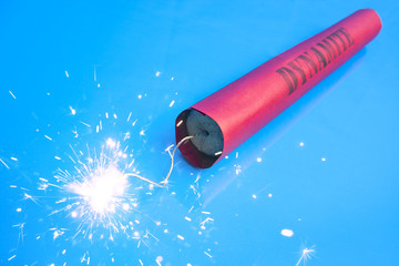 Poster - Lit dynamite stick on a blue background